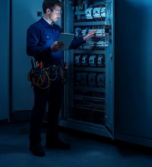Engenheiro executando manutenção em infraestrutura elétrica para empresas